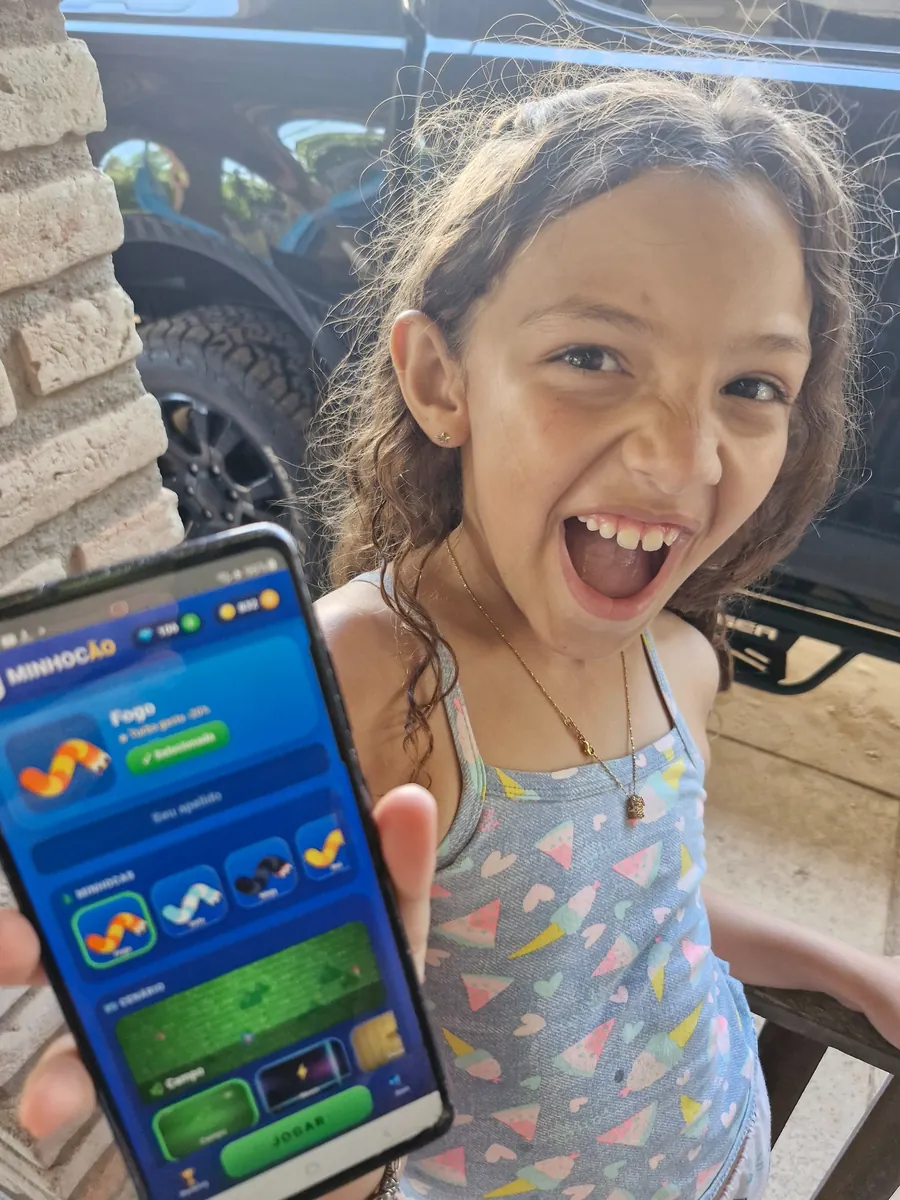 Ísis mostrando no celular o jogo que ela criou